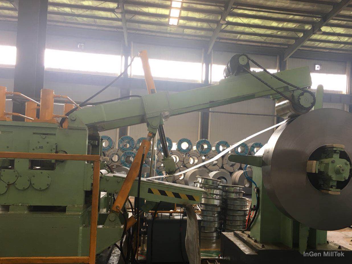 Entry section at a tube mill: single-side hydraulic uncoiler, hold-down arm and leveler entry