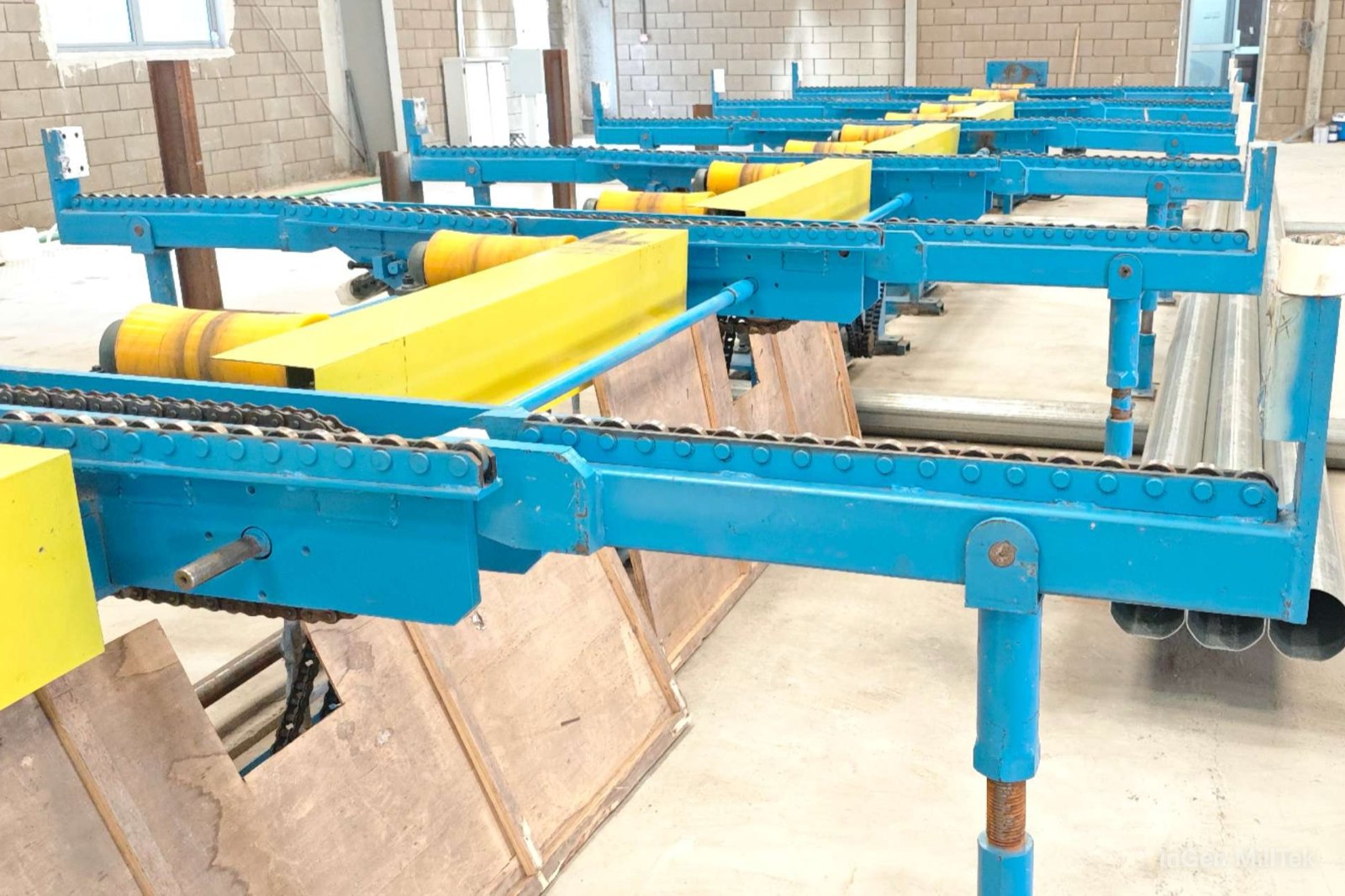 Chain-transfer run-out table at a tube mill, with finished tubes beside it