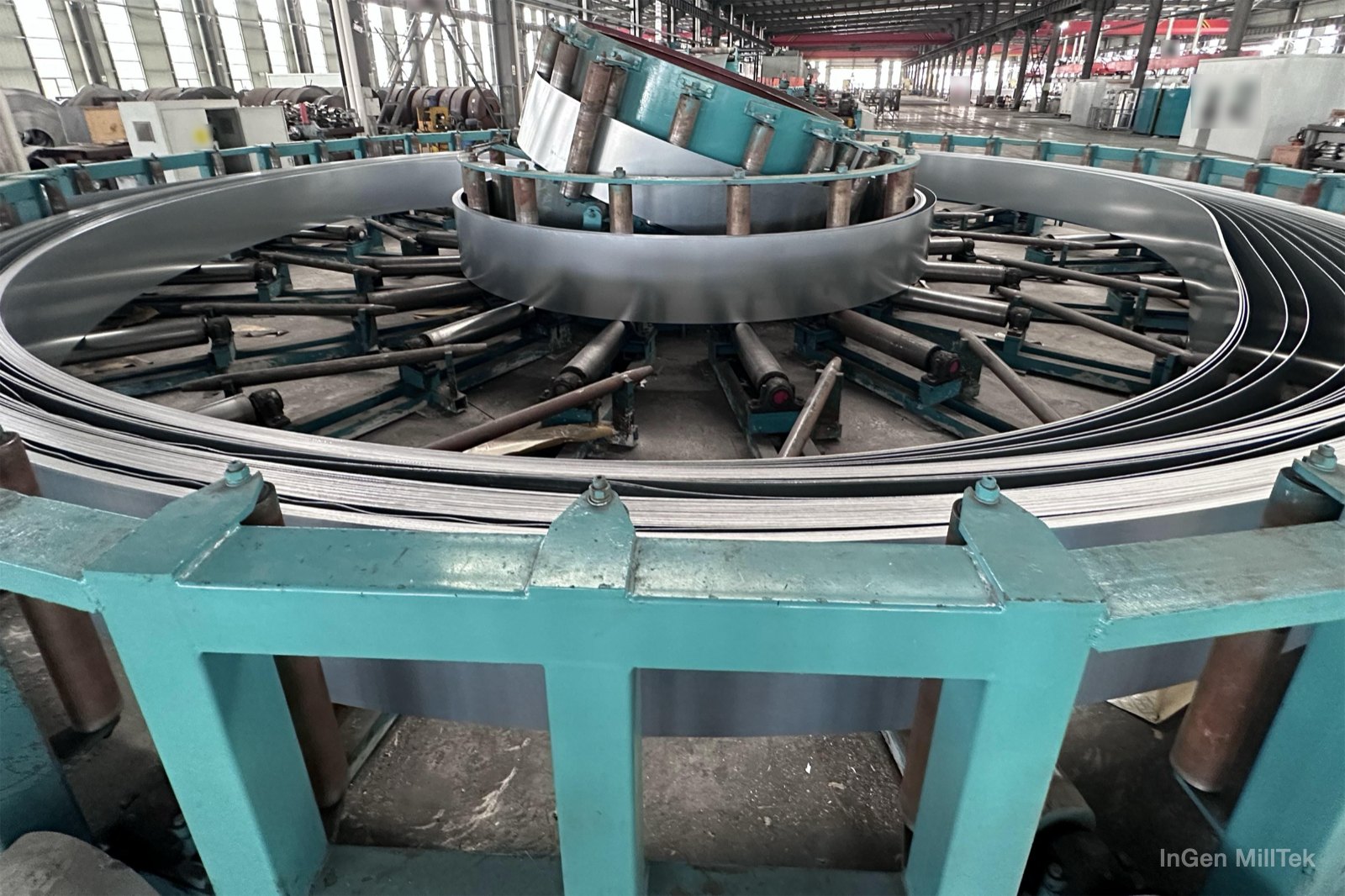 Large floor-type spiral accumulator in a tube plant, filled with strip, with the inclined central guide drum